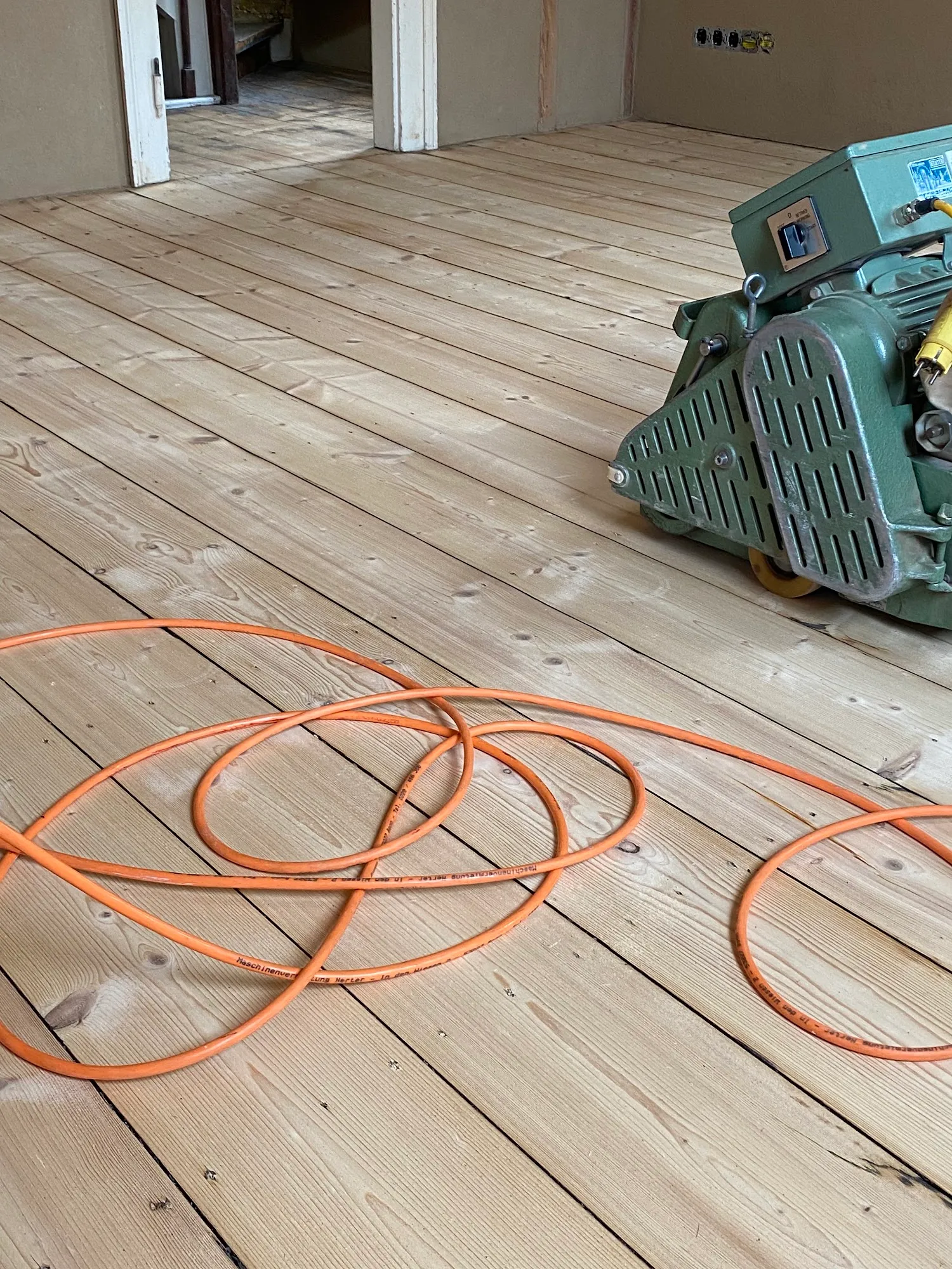 Parkettschleifmaschine im Einsatz auf Holzboden